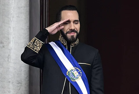 (FILES) El Salvador's President Nayib Bukele salutes during the military parade after being sworn in at the National Palace in downtown San Salvador on June 1, 2024. El Salvador's ruling-party-dominated Congress is discussing indefinite presidential reelection on July 31, 2025, aiming towards President Nayib Bukele's continued presidency. This reform also proposes extending the term of office from five to six years.