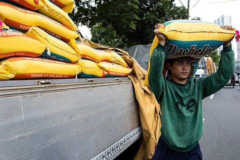 WORKER carries sacks of rice along Dagupan Street in Tondo, Manila on Tuesday. Peasant group Kilusang Magbubukid ng Pilipinas slammed the DA’s plan to halt rice imports and restore the 35 percent farmgate price, calling it a ‘mere reactive measure’ to the ongoing rice industry crisis.