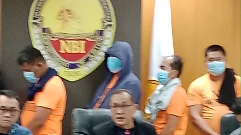 National Bureau of Investigation (NBI) Director Jaime Santiago presents San Simon Pampanga Mayor Abundio Punsalan Jr. (back center with blue hood) on 7 August 2025.
