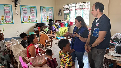 Volunteers speak with a family at the Northville Elementary School evacuation center in Calumpit, Bulacan recently.