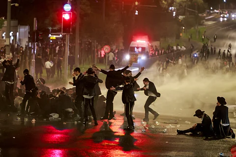 Israeli police uses a water canon to disperse ultra-Orthodox Jewish demonstrators as they protest their conscription in Israel's military and the arrest of religious school students who avoided draft orders, during a rally in Jerusalem on August 7, 2025.