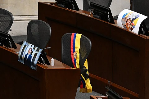 A picture of Colombian presidential candidate Miguel Uribe and his sash are displayed at his seat in Congress in Bogota on August 11, 2025. Colombian presidential candidate Miguel Uribe died two months after being shot in the head at a campaign event, his wife announced early August 11, 2025. The legislator's condition had returned to critical after he suffered a new brain hemorrhage related to the assassination attempt during a rally on June 7, in which he was shot three times, twice in the head.