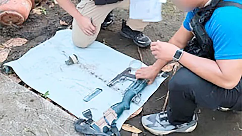 OPERATIVES inspect firearms seized during a manhunt and arrest operation against high-profile fugitives in Barangay Lamin, Lumbayanague, Lanao del Sur.