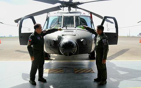 Philippine Air Force Air Mobility Command commander MGen. Ramil Oloroso (right) and PAF commander Lieutenant General Arthur Cordura lead the ceremonial pouring of champagne on the newly acquired S-70i Black Hawk helicopter on Wednesday at Clark Air Base, Mabalacat City, Pampanga.