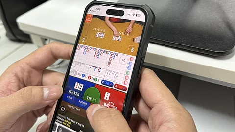 A customer plays an online gambling game on a mobile phone. Digital wallet providers GCash and Maya suspended in-app gaming access on 16 August in compliance with a Bangko Sentral ng Pilipinas directive.