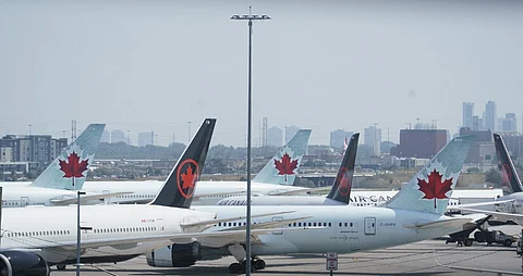 Air Canada airplanes stand on the tarmac at Pearson International Airport in Toronto on August 16, 2025. Air Canada cancelled hundreds of flights Saturday as it began shutting down operations in response to a strike by flight attendants -- triggering summer travel chaos for its 130,000 daily passengers. Canada's largest airline, which flies directly to 180 cities worldwide, urged customers not to go to the airport if they have a ticket for Air Canada or its lower-cost subsidiary Air Canada Rouge.