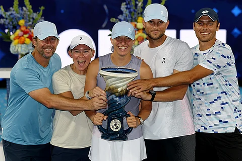 MASON, OHIO - AUGUST 18: Iga Swiatek of Poland poses with the Rookwood Cup alongside coach Wim Fissette, sports psychologist Daria Abramowicz, fitness coach Maciej Ryszczuk and hitting partner Kacper Zuk after defeating Jasmine Paolini of Italy during the women's final of the Cincinnati Open at Lindner Family Tennis Center on August 18, 2025 in Mason, Ohio.