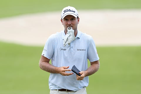 Russell Henley holds his glove with his lips as he walks the 18th fairway during the first round of the Tour Championship 2025 at East Lake Golf Club on Thursday in Atlanta, Georgia.