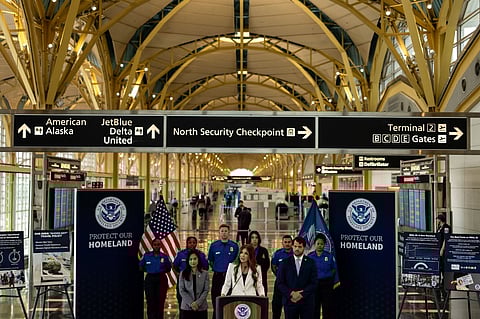 (FILES) U.S. Secretary of Homeland Security Kristi Noem, flanked by Deputy Administrator of the Transportation Security Administration Ha McNeil and Adam Stahl, TSA Senior Official Performing the Duties of the Administrator, speaks during a news conference at Ronald Reagan Washington National Airport on July 8, 2025 in Arlington, Virginia. For the first time in nearly two decades, the TSA is easing its shoe removal rule introduced five years after a 2001 shoe-bombing attempt by allowing some travelers to keep their shoes on at security checkpoints.
