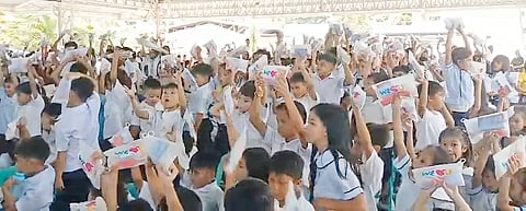 STUDENTS of Macabud Elementary School get hygiene kits from volunteers of the International WeLoveU Foundation.
