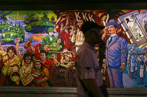 Pedestrians walk past mural and bas-relief sculptures depicting national and modern-day heroes at the Lagusnilad Underpass in Manila ahead of the National Heroes Day celebrated every last Monday of the month of August.