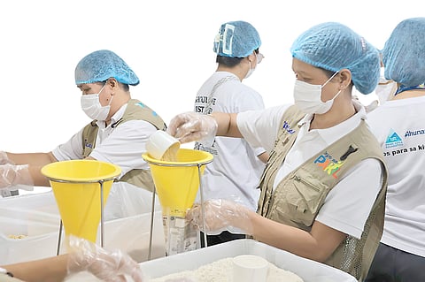 VOLUNTEERS from Prime Infra Foundation, Ahunan Power and Rise Against Hunger Philippines pack rice-soy meals for distribution to Grades 1 to 6 students of Saray Elementary School in Pakil, Laguna.