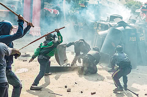 PEOPLE clash with riot control members of the Mobile Brigade Corps in the midst of a tear gas cloud, during a protest following the death of a motorcycle taxi driver the night before, in front of its headquarters in Jakarta, Indonesia on 29 August 2025.