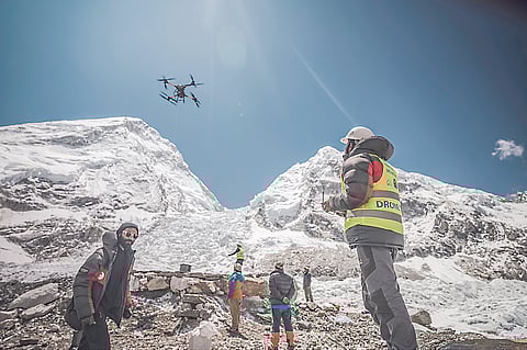 A MAN operates a heavy-lift drone to clear trash dumped at the Everest Base Camp.