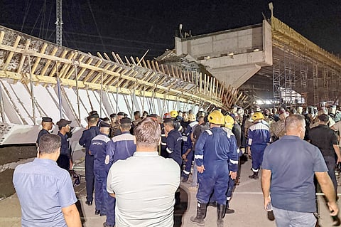 FIRST responders and onlookers gather in front of a bridge under construction, after a section of it collapsed, killing two people and injuring others, in Karbala in southern Iraq late on 6 September 2025.