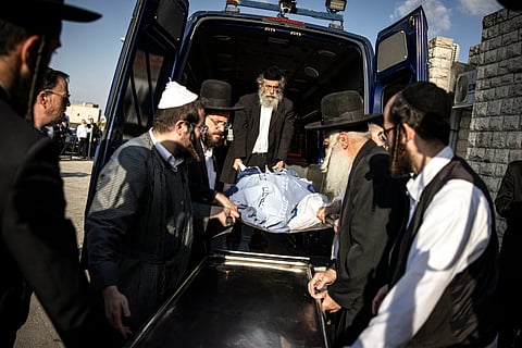 Ultra-Orthodox Jewish men transport the shrouded body of Levi-Ytzhak Pash at the Shamgar funeral home, during this funeral in Jerusalem on September 8, 2025. Palestinian gunmen opened fire at a bus stop in Israeli-annexed east Jerusalem on September 8, killing six people and wounding several others. Police said the two gunmen were also killed.