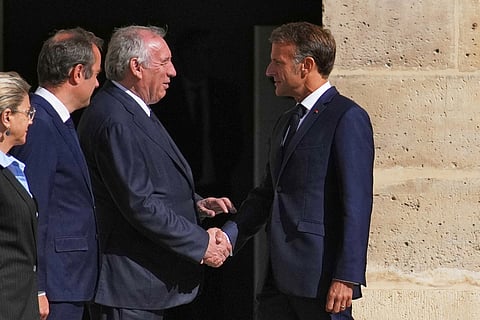 France’s President Emmanuel Macron (right) shakes hand with France’s Prime Minister Francois Bayrou (center) upon his arrival for a farewell to arms ceremony for former chief of staff of France’s armed forces in the courtyard of the Hotel des Invalides in Paris.