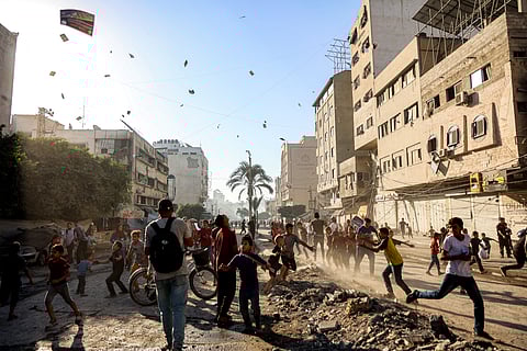 People watch as leaflets dropped by the Israeli military, urging evacuation south to al-Mawasi, land in Gaza City on 9 September 2025. The Israeli military said on Tuesday that it will act with ‘greater force’ in Gaza City and warned residents to flee, in a statement posted on X. Israel has been intensifying its bombardment of the city in preparation for an operation to take control of it, despite repeated entreaties from Western nations and aid agencies to stop.