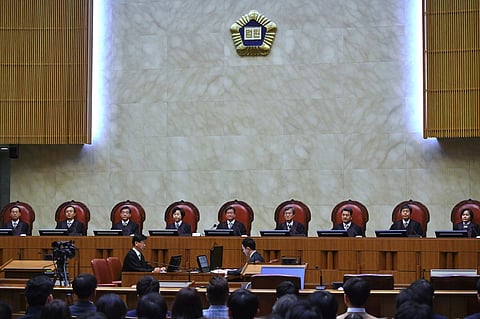 (FILES) South Korea's Supreme Court chief justice Kim Myeong-su (C) delivers the court's ruling on a conscientious objector's conviction of refusing to do mandatory military service, at the court in Seoul on November 1, 2018. South Korea's supreme court ruled on November 1 that moral and religious beliefs are valid reasons to refuse the country's mandatory military service, in a case that has implications for hundreds of conscientious objectors.