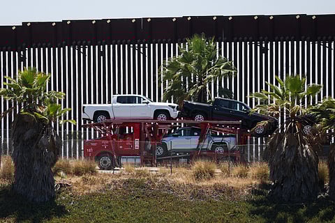 A truck carrying Toyota pickup trucks drives along a section of border wall after entering the US from Mexico, crossing the border at the US Customs and Border Protection (CBP) Otay Mesa Land Port of Entry, in Otay Mesa, California on July 31, 2025. US President Donald Trump's decision to postpone higher tariffs on Mexican goods "safeguards" an existing North America free trade deal, President Claudia Sheinbaum said on July 31. Mexico's government had reached "the best possible agreement" compared with other nations also threatened with new US import duties, she said at her morning news conference after speaking with Trump.