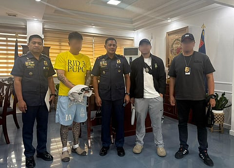 Police officers present the South Korean fugitive who was arrested for his involvement in a P200-million investment fraud scheme.