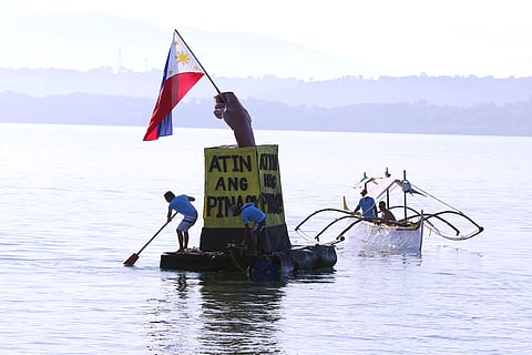 Filipino fishermen in Barangay San Salvador, Masinloc, Zambales, mounted a Philippine flag and a sign that declares that Philippine waters belong to Filipinos.