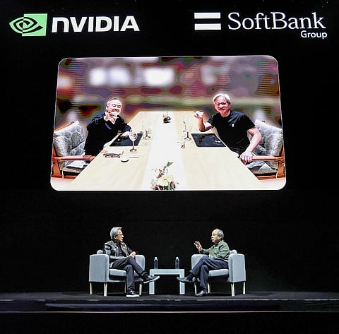 Nvidia CEO Jensen Huang (L) speaks with the CEO of the SoftBank Group Masayoshi Son during an AI event in Tokyo on November 13, 2024.