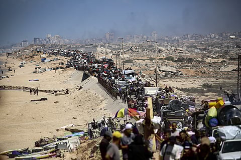 Palestinians from Gaza City move southwards with their belongings, on the coastal road near the Nuseirat refugee camp in the central Gaza Strip, on September 19, 2025. The Israeli military warned on September 19, that it will operate with "unprecedented force" in Gaza City, urging residents to flee southwards while announcing the closure of a temporary evacuation route opened 48 hours earlier.