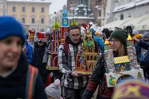 Participants are seen as they parade with nativity scenes they made for the annual Krakow Nativity Scene Contest on the Main Market Square in Krakow's old town, December 7, 2023. Towers, dragons, stained glass windows, sometimes political figures, all in an explosion of color - that's what Krakow's unique traditional nativity scenes look like, inspired by the medieval architecture of Poland's "City of Kings".