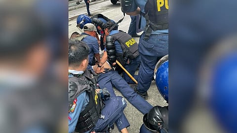 TRIBUNE photographer Toto Lozano(wearing cap) jumps in to perform CPR on a police officer mauled by protesters.
