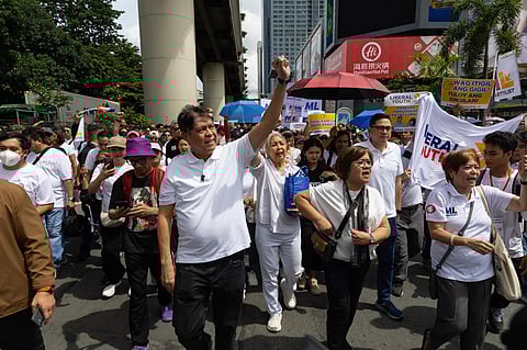 Senator Kiko Pangilinan marches alongside ML Party-list Rep. Leila de Lima towards EDSA Shrine in Quezon City on 21 September