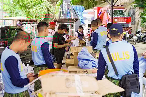 POLICEMEN and volunteers pack relief goods for residents affected by storm 'Opong' in Masbate.