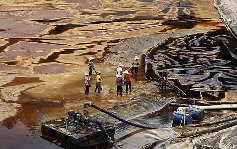 Workers drain away polluted water near the Zijin copper mine in Shanghang on July 13, 2010, after pollution from the mine contaminated the Ting river, a major waterway in southeast China's Fujian province. China's top gold producer Zijin Mining defended its handling of a toxic pollution spill that killed off vast numbers of fish, saying heavy rains were to blame, as the company's shares slumped.