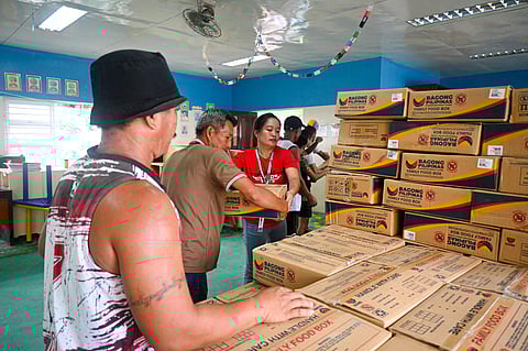 Employees and students join forces to unload the additional 2,000 Family Food Packs from the Department of Social Welfare and Development Field Office-Bicol Region in Cataingan, Masbate.