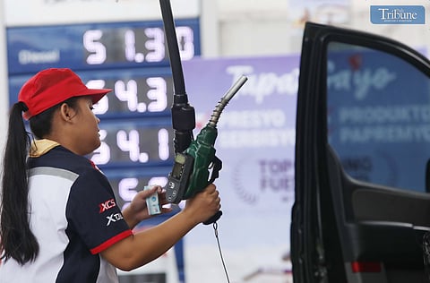 Gas station attendant assists motorists in Quezon City as fuel prices are projected to move in mixed directions next week.