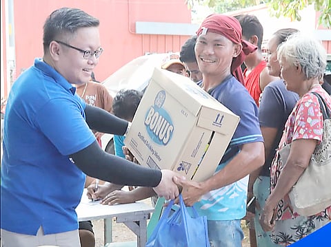 SM Cares volunteers distribute relief goods to affected residents of SM Cares Village in Barangay Polambato, Bogo City, Cebu.