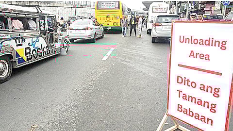 Traffic enforcers guide commuters to the right loading and unloading sites along the streets of Marikina on Tuesday morning.