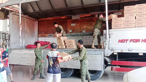 Soldiers help out in distributing relief goods to residents of Lupon, Davao Oriental who were affected by earthquakes recently.