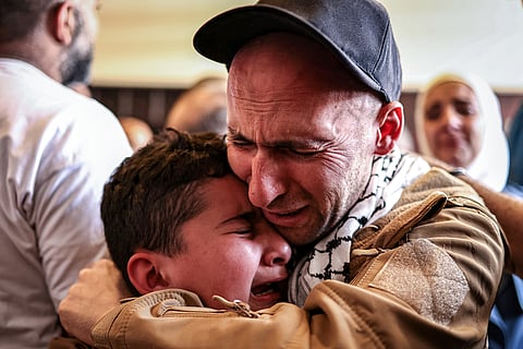 Tearful hug A Palestinian prisoner, released under a prisoner-hostage swap and ceasefire deal between Israel and Hamas, embraces a boy upon arriving by bus at Ramallah Cultural Centre in Ramallah, West Bank, on Monday. He was freed from Ofer military prison in the Israel-occupied Palestinian territories.