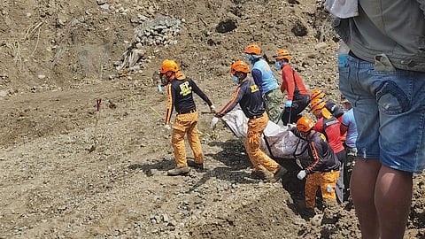 Disaster responders carry the remains of the missing couple who were swept by a landslide at the Bukidnon-Davao Road. Their bodies were found with the help of rescue dogs Venom (top most), Bella and Paul as authorities conduct search and retrieval operations at Barangay Palacapao on Thursday.