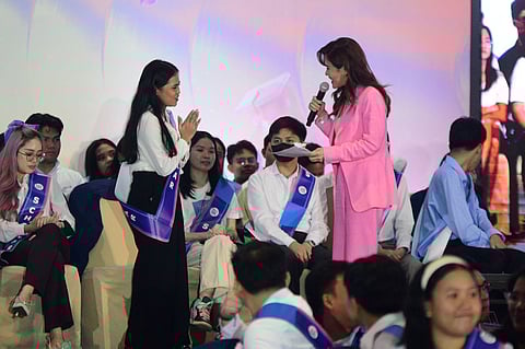 Wela Beryl Autor (standing, left), a summa cum laude graduate of Bachelor of Science in Education Major in English at Jose Rizal University, was interviewed by the host Valerie Tan (standing, right), after her education journey was unveiled in a video clip at the Presentation of SM Scholar Graduates for School Year 2024-2025 at the SMX Convention Center, Pasay City, on Thursday.