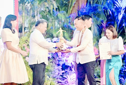 VICTOR Persius Chan (right) receives the College of Human Ecology Distinguished Alumni Awards during the 107th UPLB Loyalty Day on 9 October.