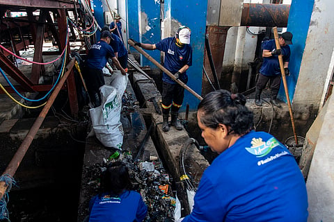 Workers collect trash from the Estero de Sunog Apog near the pumping station in Tondo, Manila on Wednesday, 12 November 2025, during the launching of the Oplan Kontra Baha of the Department of Social Welfare and Development.
