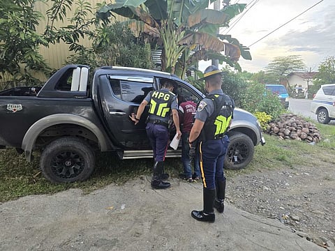 Members of the Philippine National Police-Highway Patrol Group inspect the stolen vehicle that was allegedly used in a Talon-Casa financing scheme.