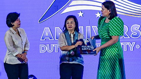 Honoring history Vice President Sara Duterte (right) presents a commemorative coffee table book to former President Gloria Macapagal-Arroyo (middle), who also assumed the post, during the 90th anniversary of the Office of the Vice President in Makati City.