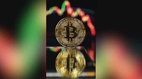 Bit of a fall Gold plated souvenir Bitcoin coin is displayed in front of a computer screen with its monthly price chart. The value of the cryptocurrency has fallen sharply since reaching record heights last month, above $126,000 at the start of October.