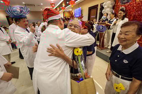 TZU Chi Medical Foundation Philippines president Dr. Antonio Say hugs a volunteer of Tzu Chi Eye Center in gratitude for their dedicated service to its patients.