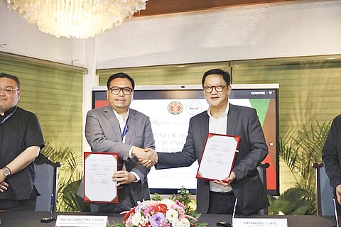 Department of Human Settlements and Urban Development Secretary Jose Ramon Aliling (left) and University of the Philippines president Angelo Jimenez seal a memorandum of agreement for a pilot rental housing project under the expanded Pambansang Pabahay para sa Pilipino (4PH) program.