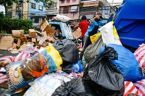 Piles of waste and garbage are being picked up by the workers from the local government of Manila’s environment department along Moriones Street in Tondo, Manila.