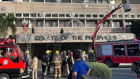 Firefighters check on the vicinity of the Senate Building in Pasay City early Sunday morning after a blaze was reported at the commercial area on the third floor.